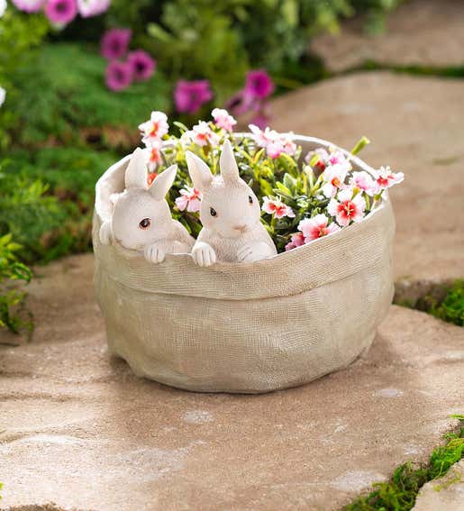 Lifestyle Image of a resin baby bunnies planter filled with pansies